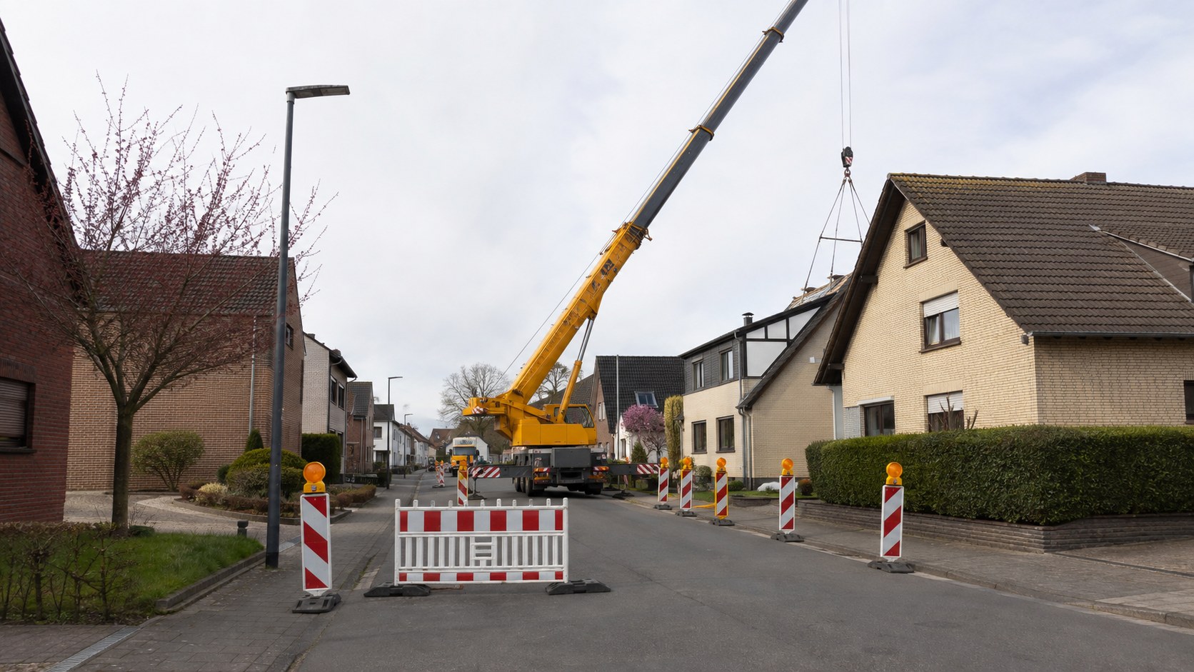 Abgesperrte Dorfstraße mit einem Autokran im Arbeitsbereich
