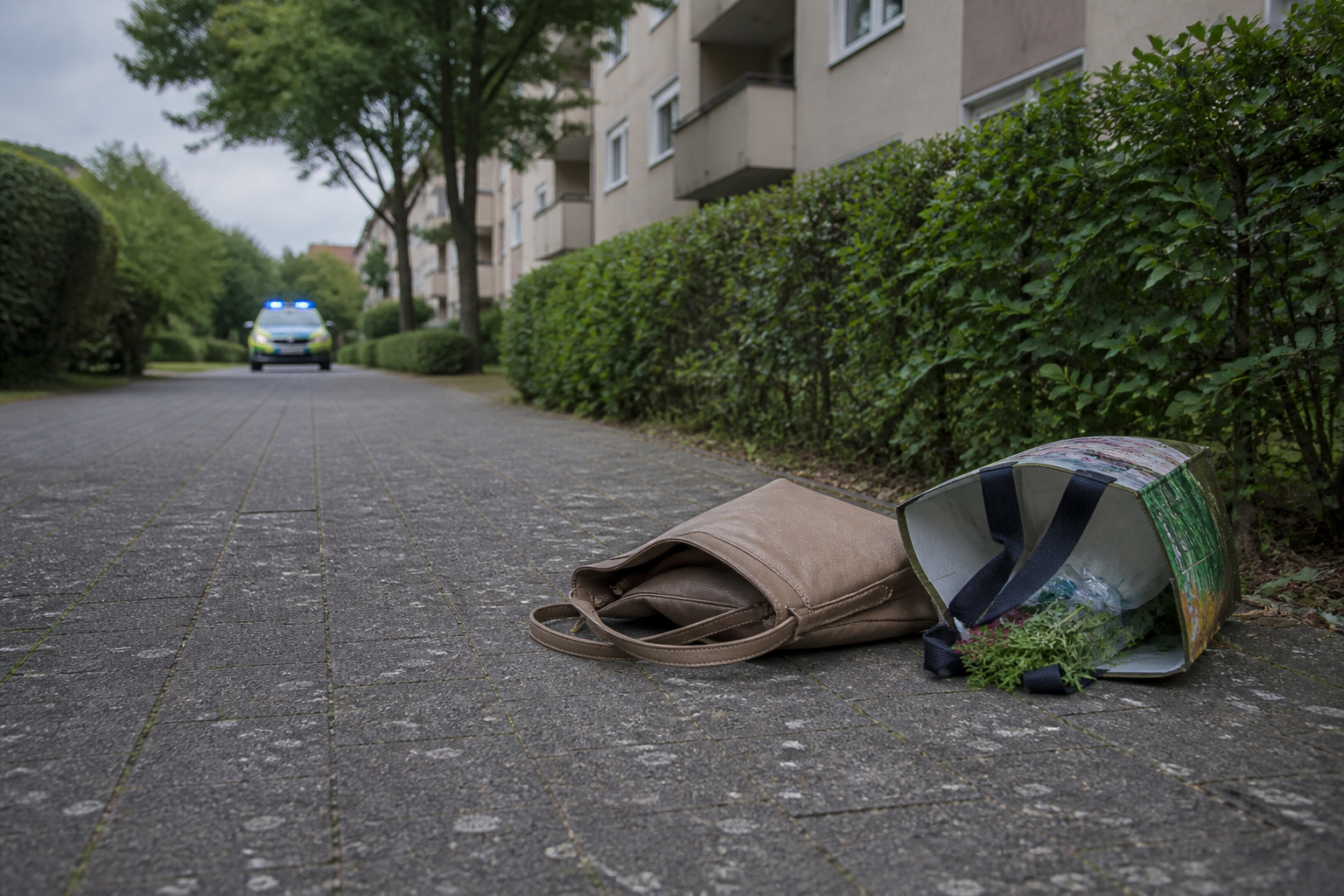Symbolbild: Eine zurückgelassene Handtasche auf einem Gehweg in einem Hürther Wohngebiet