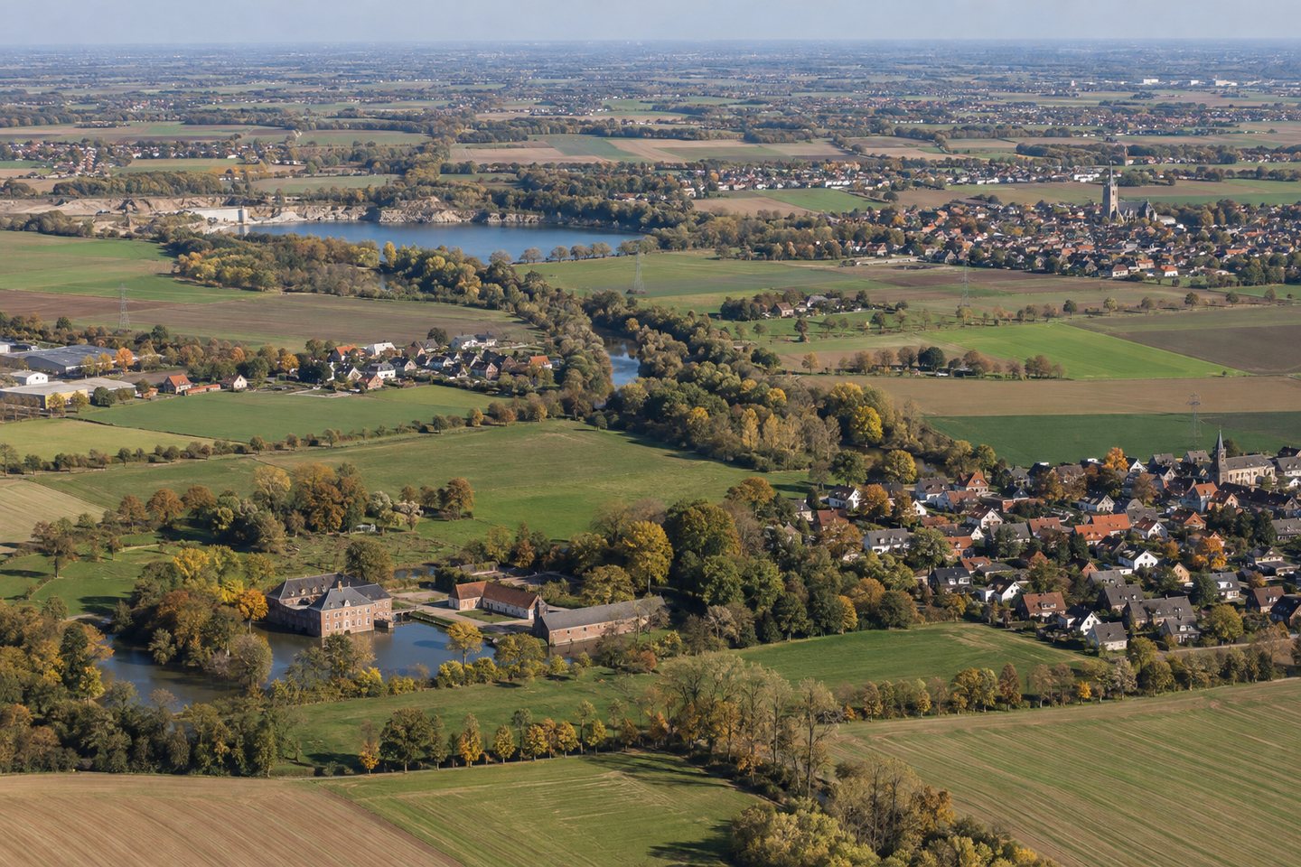 Symbolbild: Flache Erftstädter Landschaft mit Ortsteilen, Feldern, Erftaue und Wasserburg